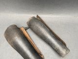 pair of old metal pipe holders in a box on a white surface