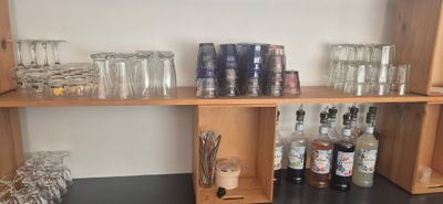 many glasses and bottles on the shelves in the room
