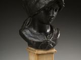 a bronze bust of a woman wearing a headscarf