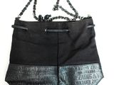 une image représentant un sac à main noir auquel est suspendue une chaîne