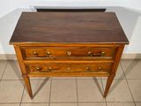 a small wooden table with three drawers on it
