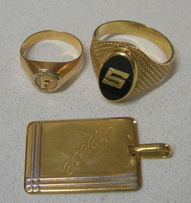 Deux bagues en or et une médaille sont posées sur une table