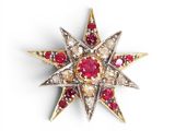 a close up of a red and white star broochle on a white surface