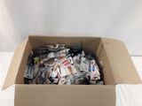 une boîte en carton remplie d'objets divers posée sur un lit