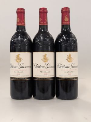 three bottles of red wine sitting on top of a white table
