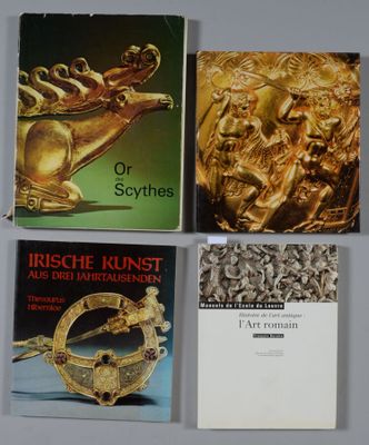 quatre livres posés sur une table, accompagnés d'une brochure dorée et d'autres objets