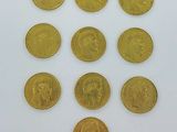 six types différents de pièces d'or sur une surface blanche