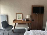 a desk with a chair and a television in a room