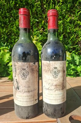 two bottles of wine sitting on a wooden table