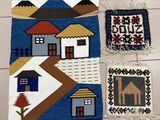 three rugs with houses on them sitting on a tile floor