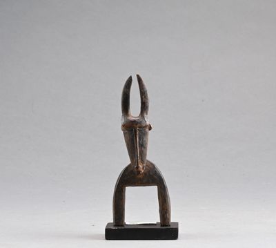 une petite sculpture en bois représentant une main tenant une paire de ciseaux