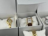 three boxes with watches and a pillow in them on a table