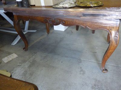 a wooden table with a bowl on it in the middle of a room