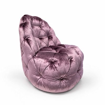 fauteuil en velours violet posé sur une surface blanche, avec un fond blanc