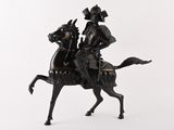 une statue représentant un homme à cheval sur fond blanc