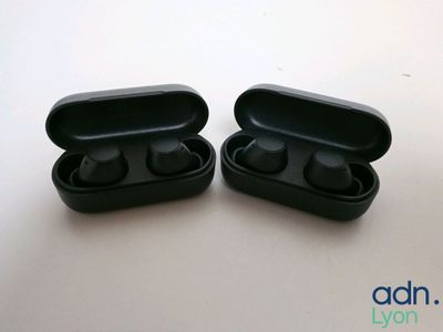 pair of black earphones sitting on top of each other on a table