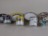 four cups and saucers are lined up on a table