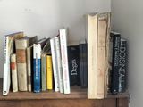 a book shelf with books and a clock on it
