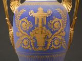 a blue vase with gold decoration on it on a black background