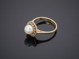 a gold ring with a pearl in the center