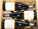 three bottles of wine are in a cardboard box on a table