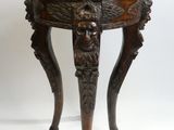 une image représentant une petite table en bois surmontée d'une tête de lion