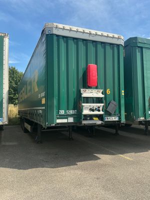 deux semi-remorques vertes garées côte à côte sur un parking