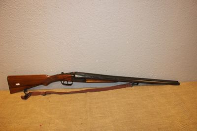 Le fusil est posé sur la table, près du mur.