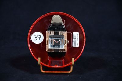 une montre posée dans un écrin rouge sur une surface noire