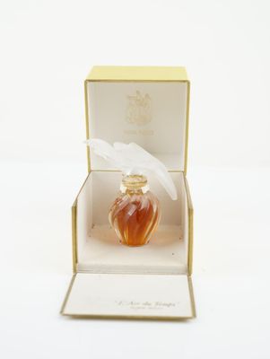 an open box with a perfume bottle inside of it on a white surface