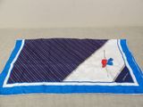 a blue and white blanket with a red flower on it