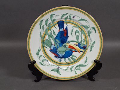 a plate with a bird on it sitting on a stand