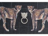 two cheetah standing next to each other with a ring in their mouth