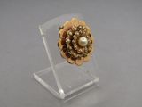gold tone flower ring with pearls on clear acrylic stand
