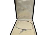 an open box with a silver necklace and a silver bracelet