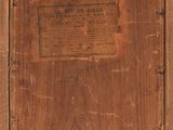an old wooden box with a label on it sitting on a table