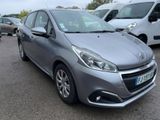 La voiture grise est garée sur le parking, à côté d'autres voitures.