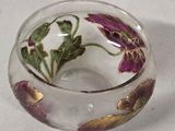 a glass bowl with flowers inside of it on a table