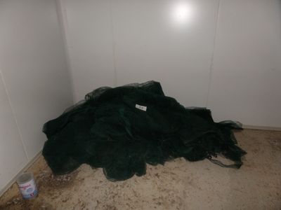 a pile of garbage on the floor in the corner of a room