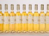 six bottles of white wine are lined up in a row