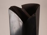 a black vase sitting on top of a white table