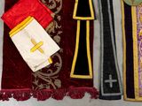 three pieces of cloth with a cross on them are laying on a table
