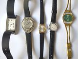 plusieurs montres différentes sont alignées sur une surface blanche