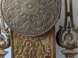 a clock that is sitting on a stand in front of a mirror