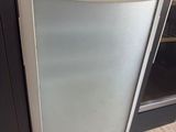 a refrigerator with a glass door in the middle of a kitchen