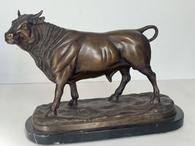 statue en bronze représentant un taureau, posée sur un socle en marbre, sur une surface blanche