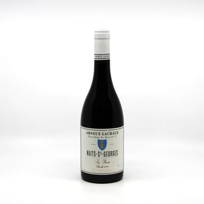 the bottle of wine is sitting on a white surface