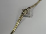 une image d'une montre-bracelet en or sur une surface blanche