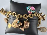 black leather purse with a gold chain and charms on it