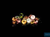 a close up of three different colored diamonds on a black surface